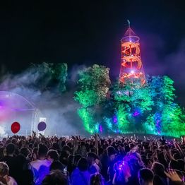 Menschen stehen bei der DasDing-Bühne unterhalb vom beleuchteten Killesberg-Turm