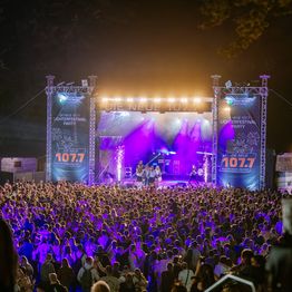 Unzählige Menschen stehen vor der Bühne der Neuen 107.7 an der Freilichtbühne und feiern.