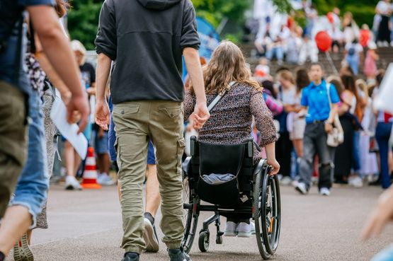 Eine Rollstuhlfahrerin schiebt sich über einen Weg im Killesbergpark