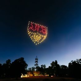 100 Drohnen formen im Nachthimmel über dem Killesbergturm mit Lichtern das Logo des VfB Stuttgart.